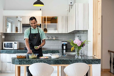 In-home cook preparing fresh home-style meals in a V are Family private villa kitchen for a comfortable family holiday.